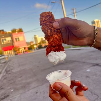 Bro’s Hot Chicken - a hand holding a piece of fried chicken - Chicken Shop Near Me - Miami, Florida Bro’s Hot Chicken - a hand holding a piece of fried chicken - Chicken Shop Near Me - Miami, Florida