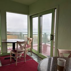 Black Sands Bistro - The enclosed porch with the two big tables (the ones inside are smaller)