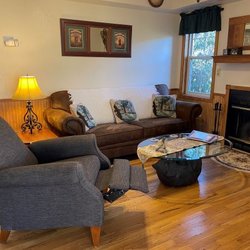 Johnson Branch Cabins - Large sofa with recliner + wood fireplace.