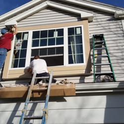 Aspen - The guys hard at work on a three light double hung window with new smart trim all around.With moisture barrier tape and header flashing A+