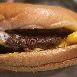McDonald's - McDouble (plain) smashed, soggy, and cheese hanging out to be side, obviously not put on straight.