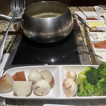 The Melting Pot - Potatoes, mushrooms, and broccoli for veggies. Sauces lined up to the right of the fondue pot. - Fondue Near Me - Tallahassee, Florida The Melting Pot - Potatoes, mushrooms, and broccoli for veggies. Sauces lined up to the right of the fondue pot. - Fondue Near Me - Tallahassee, Florida