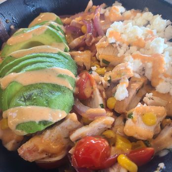 Organic Krush Kitchen & Eatery - Austin chicken bowl - A bowl containing sliced avocado, cooked chicken, rice, cherry tomatoes, corn, and sautéed onions and peppers. - Juice Bars & Smoothies Near Me - Plainview, New York