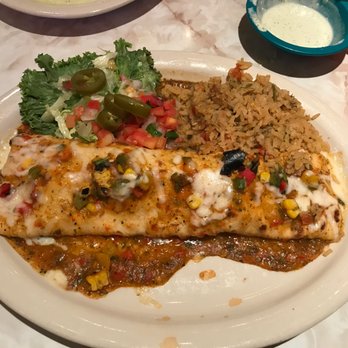 Chuy's - Burrito En Fuego - A flour tortilla stuffed with grilled chicken, Queso, green chiles, peppers and fajita veggies, covered in salsa. - Mexican Near Me - San Antonio, Texas