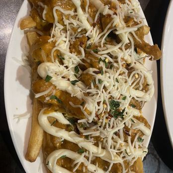 Maurya East Indian Roti - a plate of fries with cheese on top - Indian Near Me - Etobicoke, Ontario Maurya East Indian Roti - a plate of fries with cheese on top - Indian Near Me - Etobicoke, Ontario