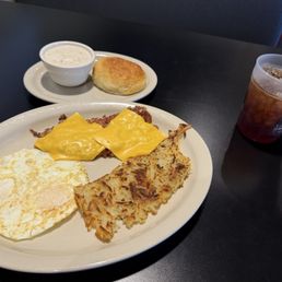 Eggs over easy, biscuit with gravy, corned beef hash with cheese. And shredded hash browns and an iced tea. Eggs over easy, biscuit with gravy, corned beef hash with cheese. And shredded hash browns and an iced tea.