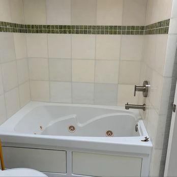 Bryant Touch Home Renovations - Before photo with the Jacuzzi tub and ugly green tile. - Handyman Near Me