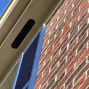 JMartini Painting & Renovations - a brick building with blue shutters - Painters Near Me