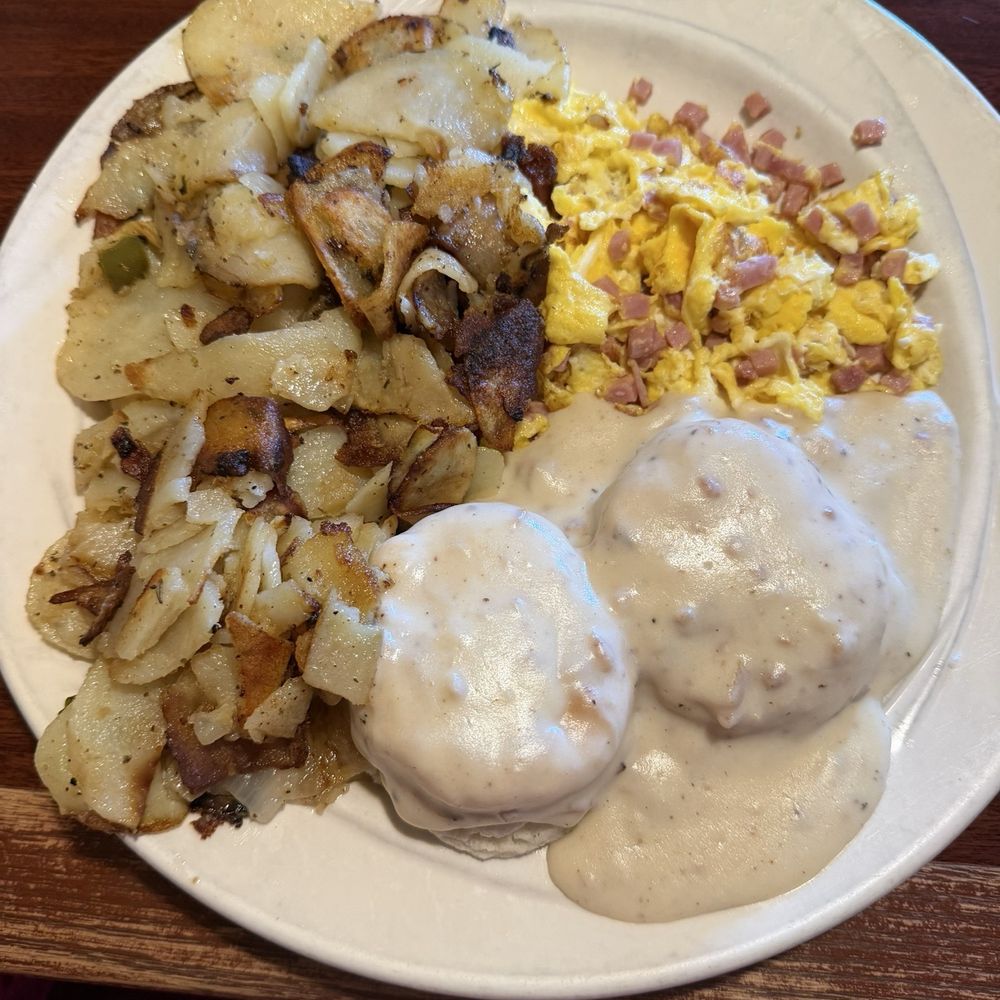Ham with scrambled eggs, biscuits and gravy and potatoes.