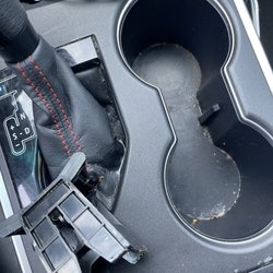 Woodman Car Wash - Cup holder divider was left off and gear shift has liquid puddles.. also not cleaned.