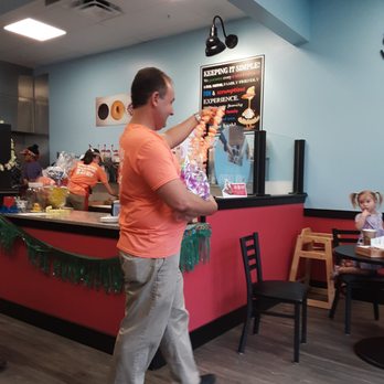 Duck Donuts - Andy, the owner, handing out leis to the customers, continuing the tropical theme going on now. - Donuts Near Me - Pittsburgh, Pennsylvania Duck Donuts - Andy, the owner, handing out leis to the customers, continuing the tropical theme going on now. - Donuts Near Me - Pittsburgh, Pennsylvania