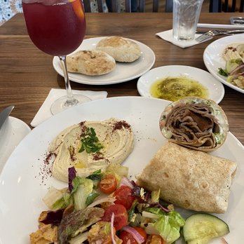 Byblos - The gyro wrap with hummus and fattoush salad. Also, you'll see freshly made pita bread and seasoned olive oil and their sangria. - Mediterranean Near Me - Harahan, Louisiana