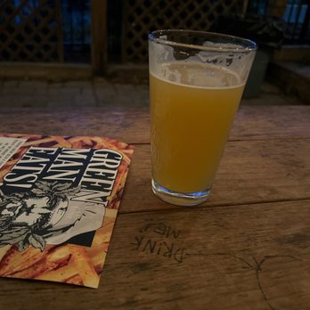 Dirty Jack's - a glass of beer and a book on a table - Bars Near Me - Asheville, North Carolina