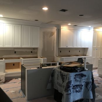 Restore Remodel Renew - Custom white shaker kitchen cabinets being installed with gray island. - Damage Restoration Near Me - Lantana, Florida Restore Remodel Renew - Custom white shaker kitchen cabinets being installed with gray island. - Damage Restoration Near Me - Lantana, Florida