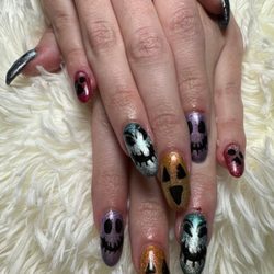 Ms Tina did my nails with powder dip and each nail has a different color cat eye polish and hand drawn halloween designs.