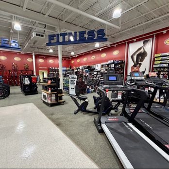 DICK'S Sporting Goods - Fitness equipment - A sporting goods store interior featuring fitness equipment like treadmills, bikes, and accessories, with bike displays on the wall. - Sports Wear Near Me - Monaca, Pennsylvania