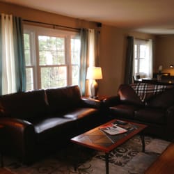 2201 Powell, LLC - Living room flows into the dining area, leather couches, love seats, chairs, dining table seats four, and lots of natural light