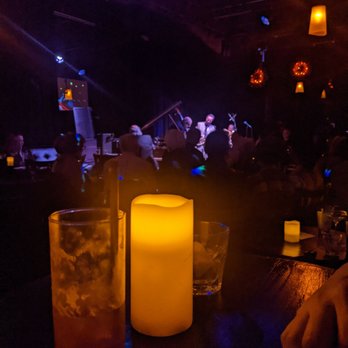 Black Dolphin - two drinks and a candle in a dimly lit bar - Jazz & Blues Near Me - Kansas City, Missouri Black Dolphin - two drinks and a candle in a dimly lit bar - Jazz & Blues Near Me - Kansas City, Missouri