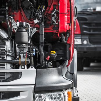 Mega Truck Trailer - Close-up view of a heavy-duty truck engine compartment showing hoses, wiring, suspension components, radiator, and mechanical... - Trailer Repair Near Me - Dayton, Ohio Mega Truck Trailer - Close-up view of a heavy-duty truck engine compartment showing hoses, wiring, suspension components, radiator, and mechanical... - Trailer Repair Near Me - Dayton, Ohio