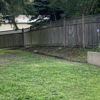 O& E Landscaping Services -  a back yard with a fence and flowers - Landscaping Near Me