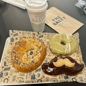 The Salty - Everything Cragel, Pistachio white chocolate donut, and the Boston Creme Movember mustache donut - Donuts Near Me - Denver, Colorado The Salty - Everything Cragel, Pistachio white chocolate donut, and the Boston Creme Movember mustache donut - Donuts Near Me - Denver, Colorado