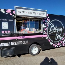 A mobile dessert cafe truck with pink and black exterior, featuring the business name Bing Tea and offering boba tea and desserts.