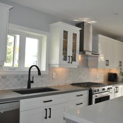 Livingston Cabinetry - Solid wood cabinets painted white. Beautiful marble backsplash. Grey quartz countertops
