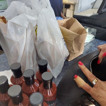 Frank's Shrimp & Chicken - a woman's hand reaching for a bottle of sauce - Chicken Wings Near Me - Mokena, Illinois