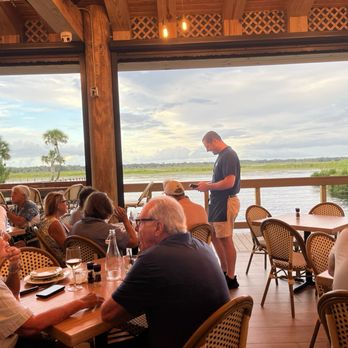 The Natives Restaurants - View of water from table under tiki hut - American Near Me - The Villages, Florida The Natives Restaurants - View of water from table under tiki hut - American Near Me - The Villages, Florida