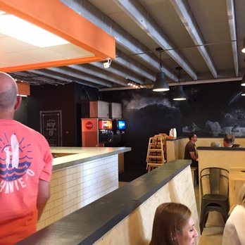 CHOM Burger - Inside orange and black decor. Bench seating. Clean, new. - Burgers Near Me - Provo, Utah