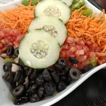 Weck's - Santa Fe Salad with Chicken - A colorful salad featuring cucumber slices, shredded carrots, diced tomatoes, black olives, and chopped green peppers in a white dish. - Breakfast & Brunch Near Me - Las Cruces, New Mexico