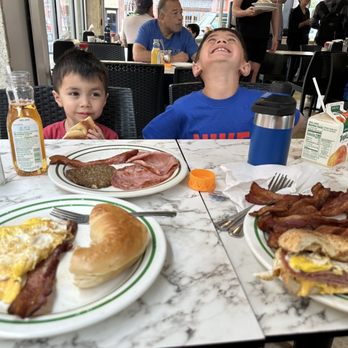Goldberg'S Famous Deli - a boy and a boy eating breakfast - Bagels Near Me - Millburn, New Jersey