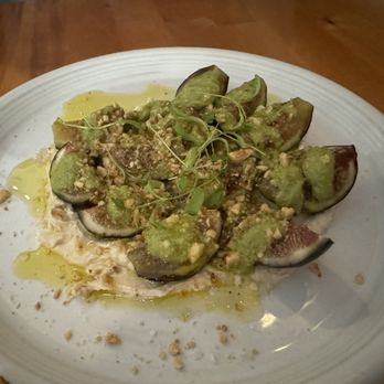 Marrow - Sierra figs - A dish featuring sliced figs topped with crushed nuts and a green sauce, garnished with microgreens, served on a white plate. - Cocktail Bars Near Me - Rochester, Minnesota