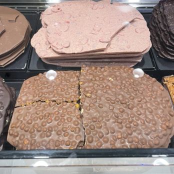 Läderach chocolatier suisse - FrischSchoggi--I think Milk Chocolate with Macadamia nuts in the front & the Strawberry Curd in the back. - Candy Stores Near Me - Livermore, California Läderach chocolatier suisse - FrischSchoggi--I think Milk Chocolate with Macadamia nuts in the front & the Strawberry Curd in the back. - Candy Stores Near Me - Livermore, California