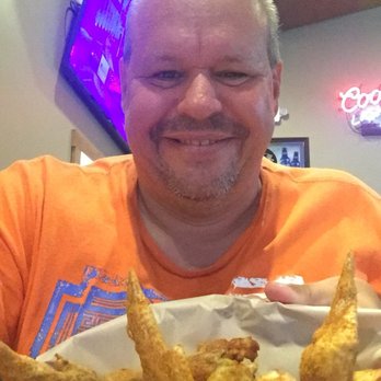 County Line Tavern - a man in an orange shirt holding a basket of fried chicken wings - Bars Near Me - Fenelton, Pennsylvania