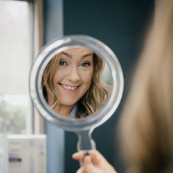 Matthews Dentistry - A patient of Matthews Dentistry looking into a mirror.