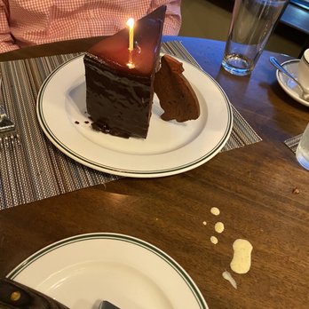 Smith & Wollensky - Wellesley - a piece of chocolate cake with a lit candle - Steakhouses Near Me - Wellesley, Massachusetts
