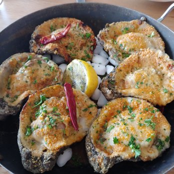 Pier 6 - Hot Blooded Oysters cooked in a bed of garlic, siracha, and habanero butter sauce covered in Parmesan cheese - Seafood Near Me - San Leon, Texas