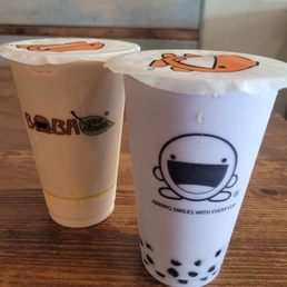 Lavender milk tea with egg pudding on the left, taro coconut milk tea with boba on the right