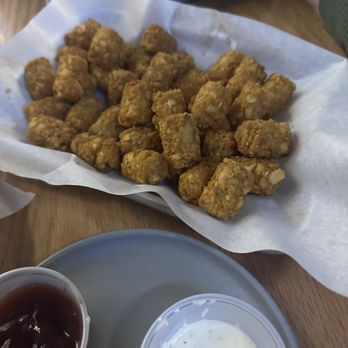 Southside Benderz - Over cooked crap - Fried chicken nuggets are served in a basket lined with paper, accompanied by dipping sauces on a wooden table. - Burgers Near Me - Avon, Colorado