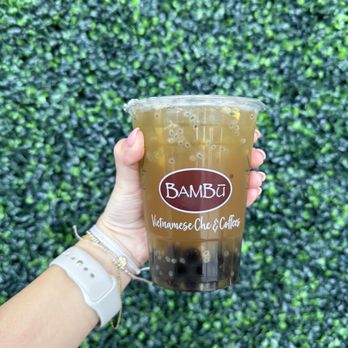 BAMBU - a hand holding a cup of iced coffee - Juice Bars & Smoothies Near Me - Grand Prairie, Texas