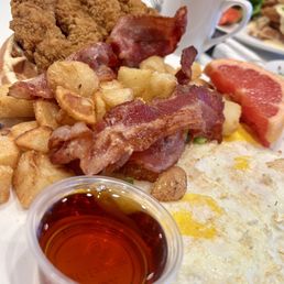 Chicken with bacon, egg, potatoes and fruits.