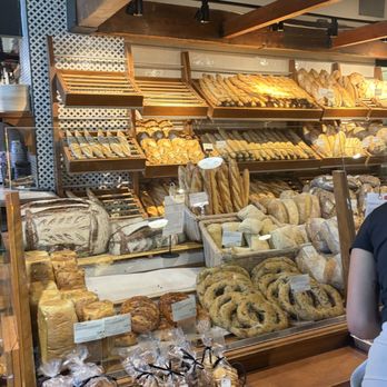 Première Moisson - Front display counter showcasing some of their breads.  (Look at that incredible olive bread shaped like a pretzel!). - Bakeries Near Me - Montreal, Quebec