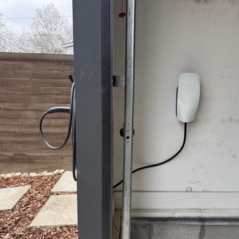 Mikes Electric - Tesla Wall Charger inside garage with charger pass through to an outside holster. - Electricians Near Me - Murfreesboro, Tennessee