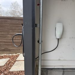 Mikes Electric - Tesla Wall Charger inside garage with charger pass through to an outside holster.