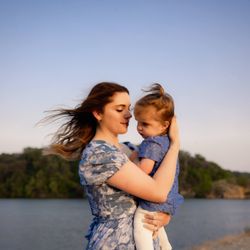 Apollo & Ivy Photography - Mom holding toddler girl near a lake with wind blowing their hair