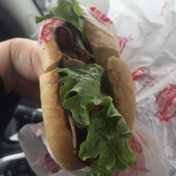 Big Apple Bagels - a hand holding a sandwich - Breakfast & Brunch Near Me - Holland, Michigan