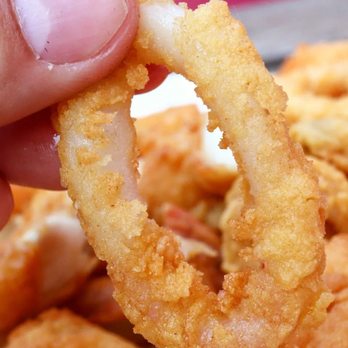 The Lobster Stop - a hand holding a fried onion ring - Seafood Near Me - Quincy, Massachusetts