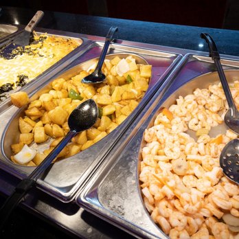 Buffet King - Shrimp, taters, and spinach (that I scrape all that cheese off of...) - Buffet-style food trays containing scrambled eggs, diced potatoes, and cooked shrimp, with serving utensils in each tray. - Chinese Near Me - Austin, Texas