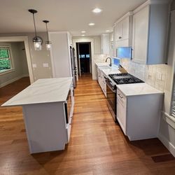 ProBuild Solutions - Bright kitchen remodel featuring white shaker cabinets, black hardware, quartz counters, island and refinished hardwood floor, new lighting.